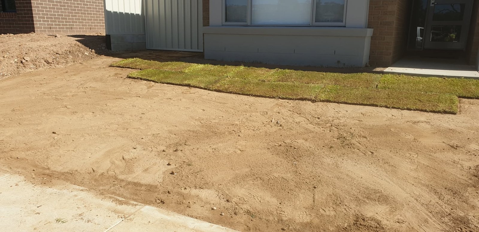 Completed retaining wall along a residential fence line