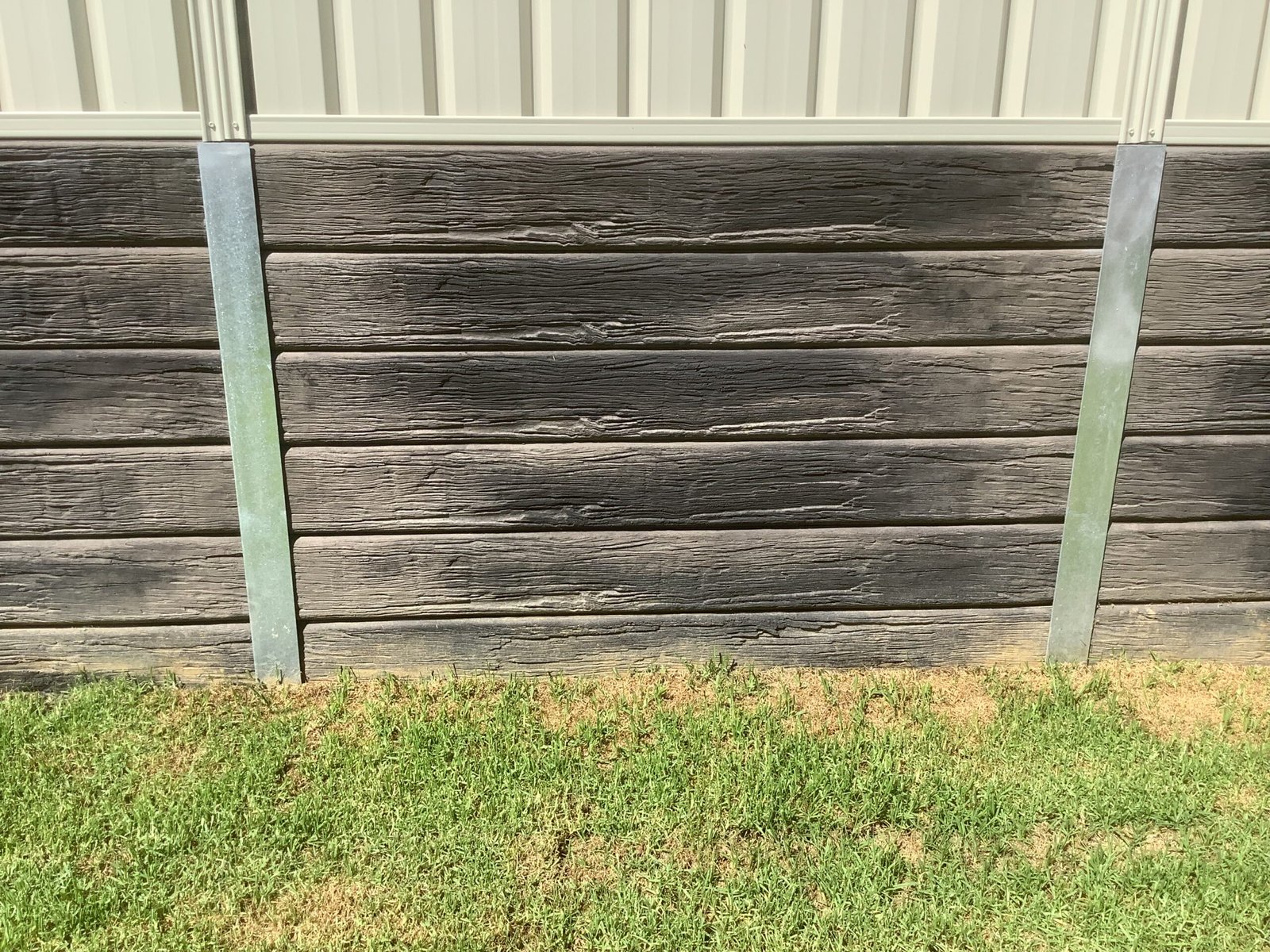 Finished timber-look concrete sleeper retaining wall and lawn by A1 Retaining