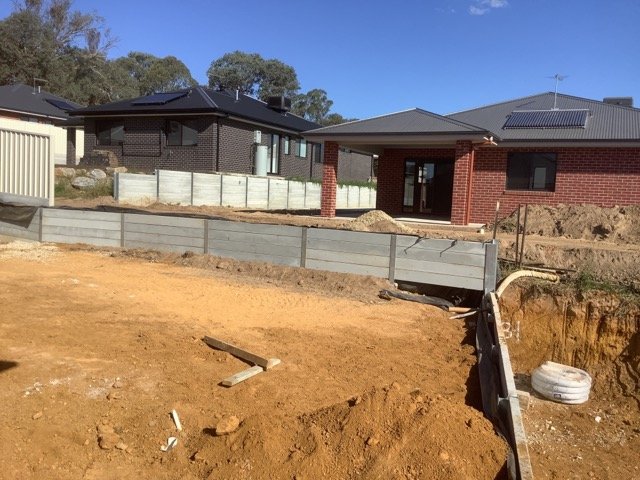 Long concrete sleeper retaining wall during residential construction