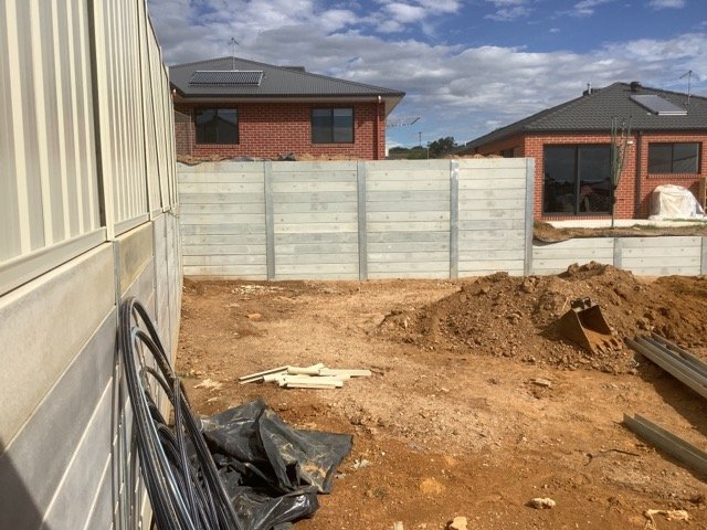 Concrete sleeper retaining wall and earthworks beside a residential property