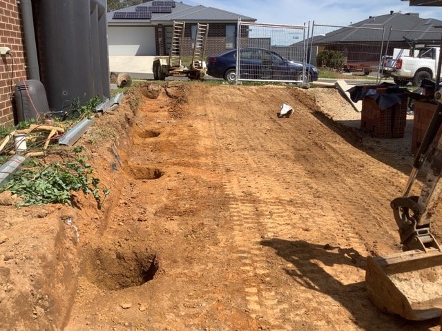 Residential site marked and excavated before retaining wall construction