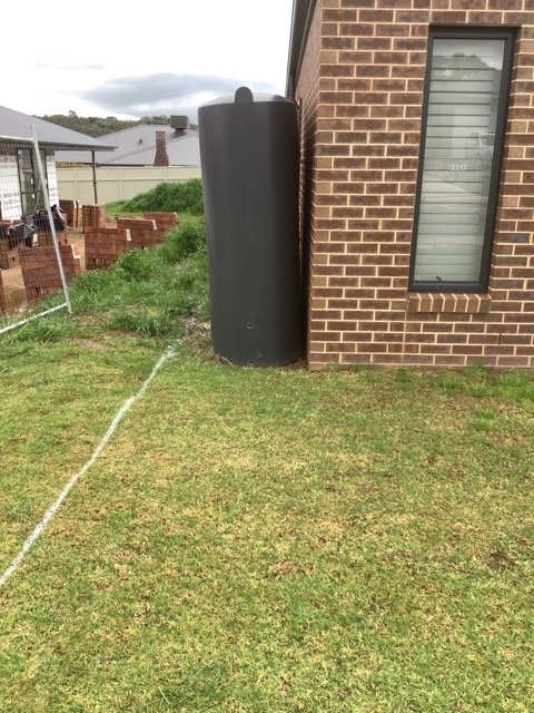 Residential lawn and building before retaining wall site preparation