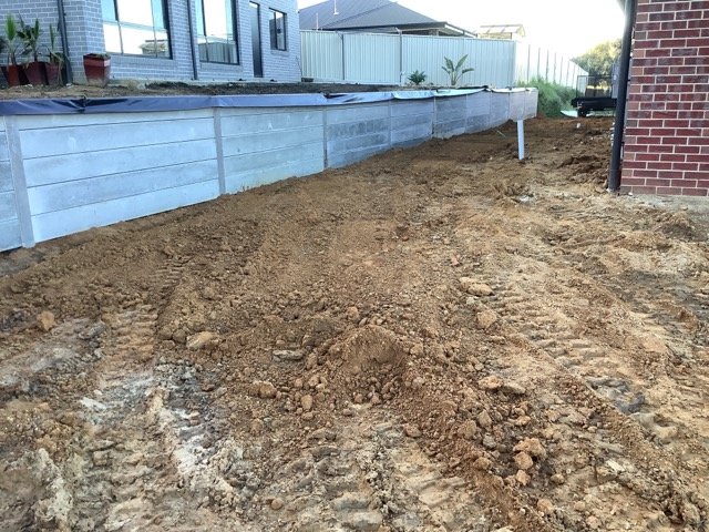 Concrete sleeper retaining wall wrapping around a residential site