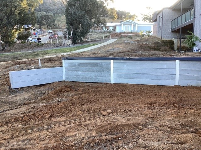 Concrete sleeper wall being built through a sloping backyard