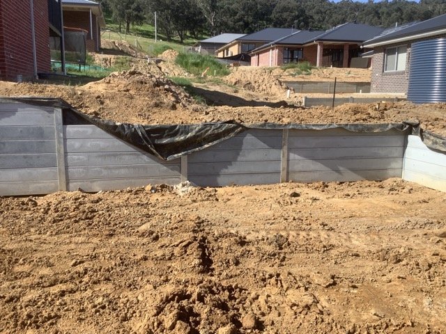 Concrete sleeper retaining wall and earthworks on a sloping residential property