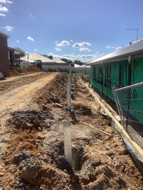 Retaining wall drainage membrane and site preparation during construction