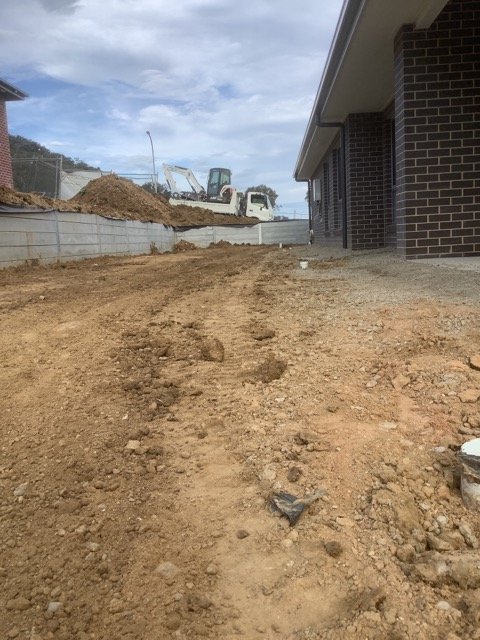 Residential earthworks and shaped ground beside a new building