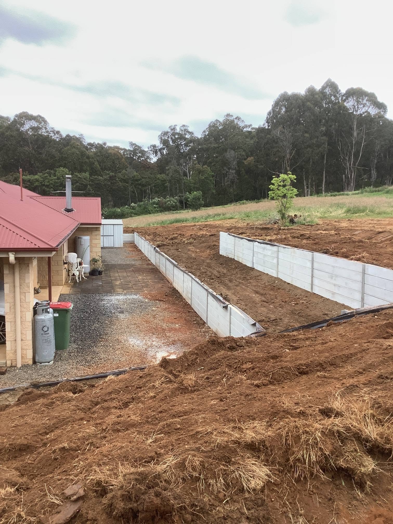 Long concrete sleeper retaining wall with broad residential earthworks