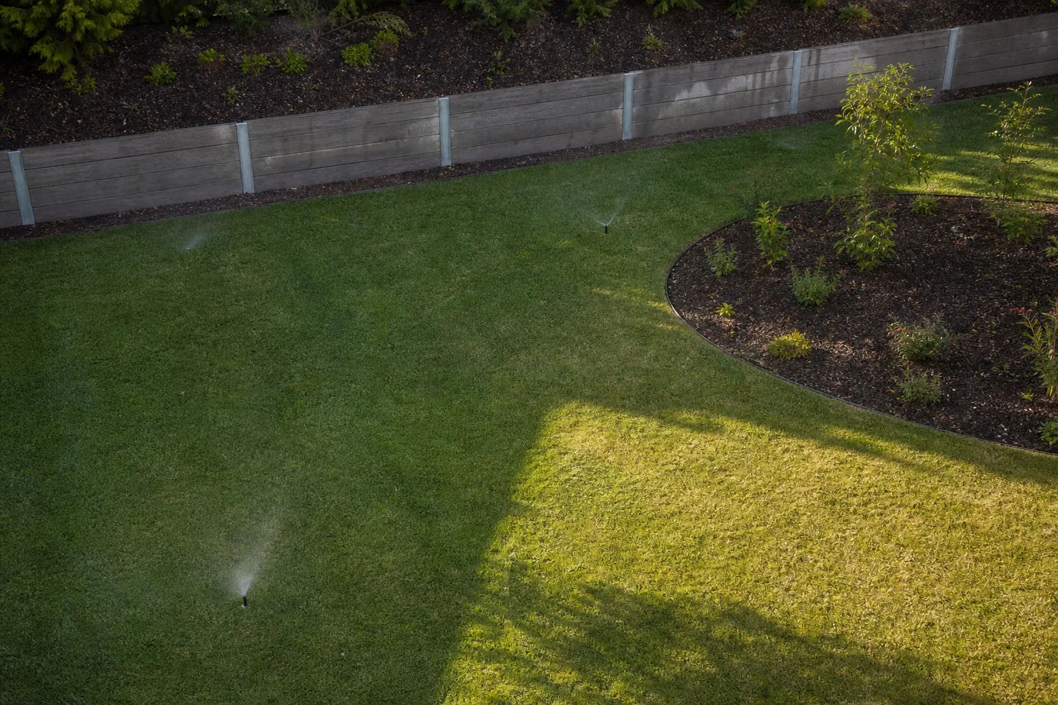 Interactive irrigation visualisation showing open lawn, a concrete sleeper retaining wall, a garden bed and a sunny lawn area